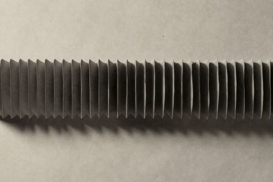 A long paper accordion fold throwing an even rhythm of shadows