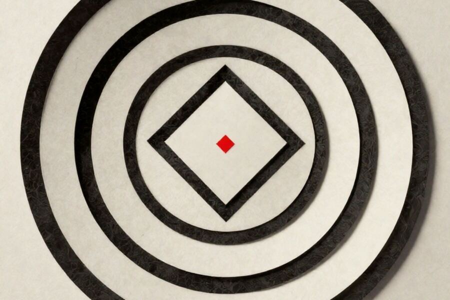 Concentric paper rings laid around a single small square at the centre