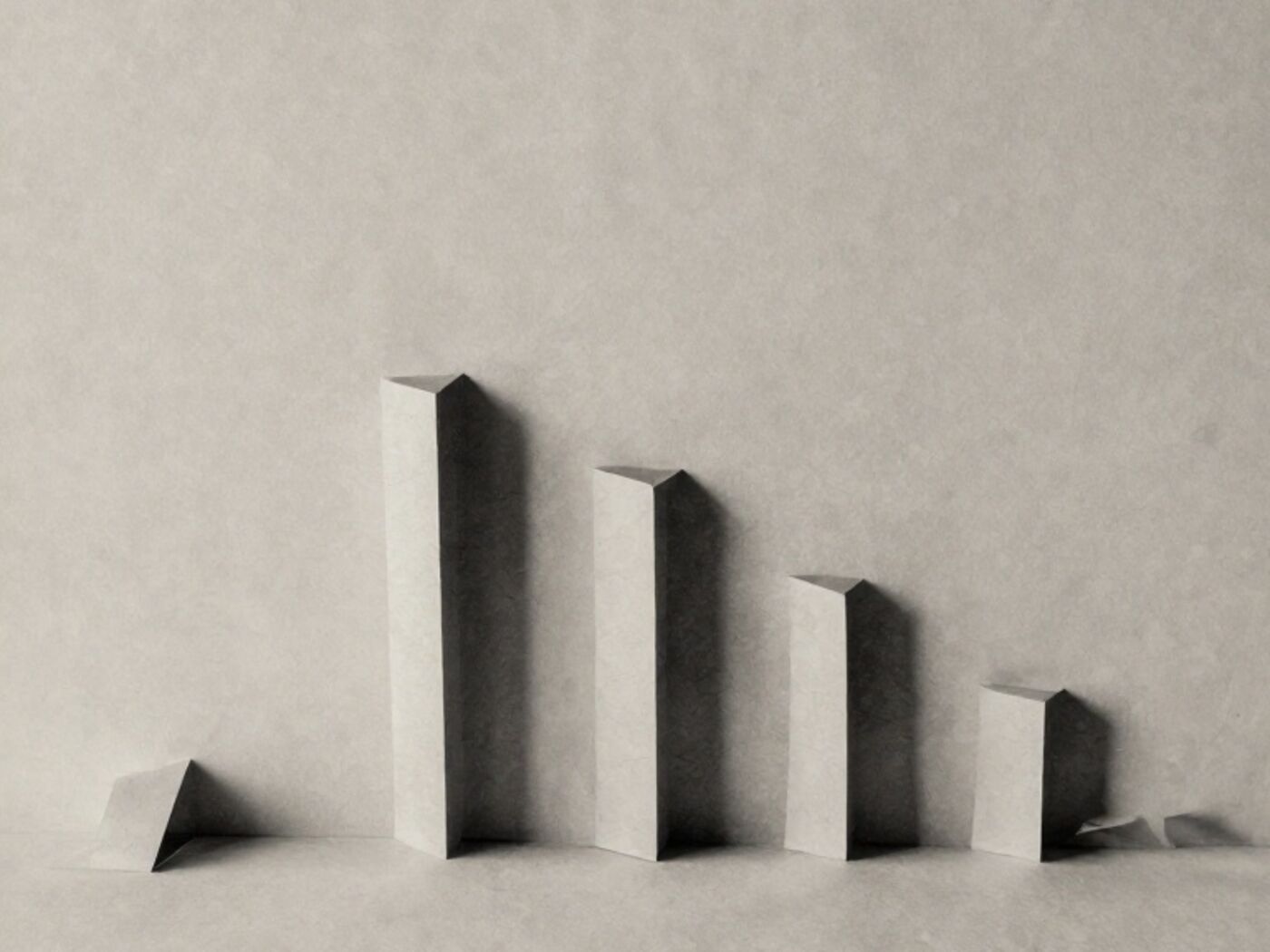 Six paper strips of differing heights standing upright in a row, like a chart made of paper
