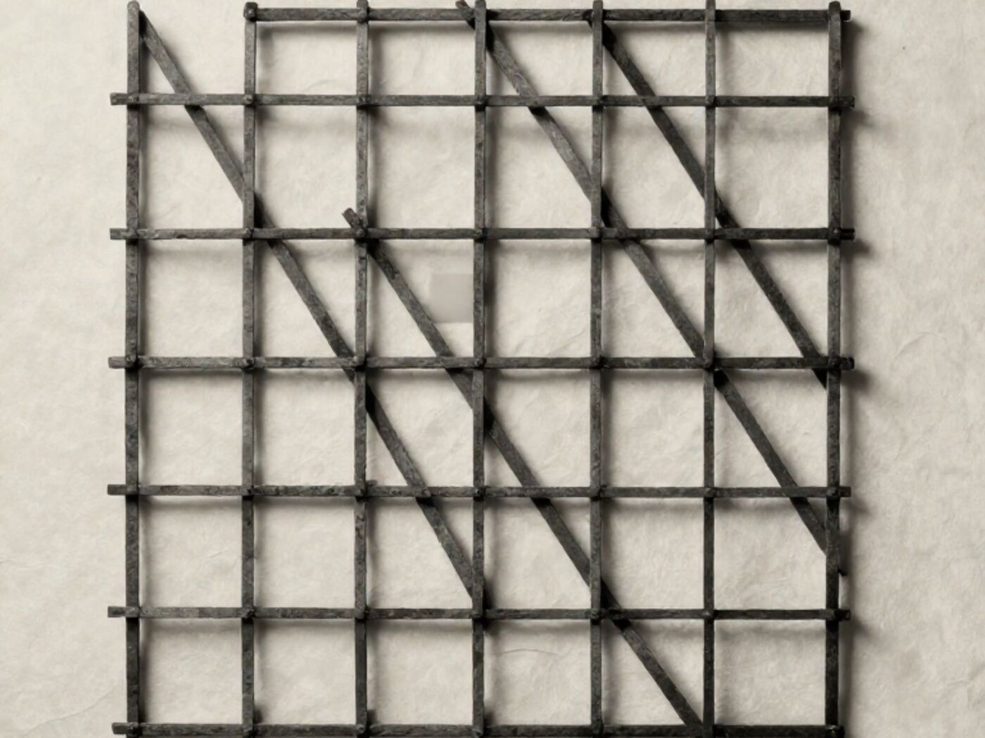 A lattice of thin dark rods laid over pale paper, with one cell filled solid